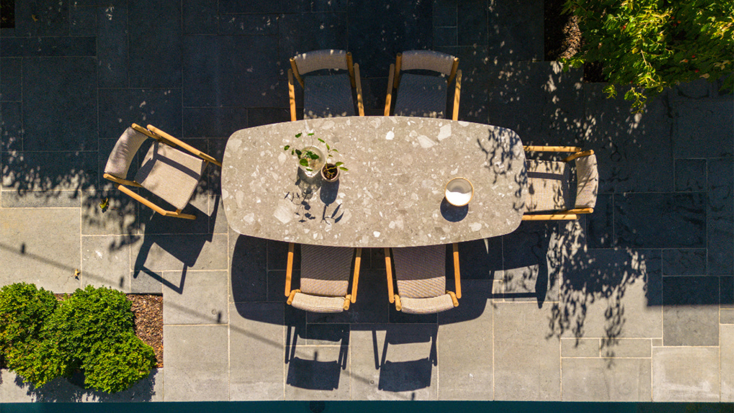 Beige table and chairs in an outdoor patio setting, pictured in a birds eye view.