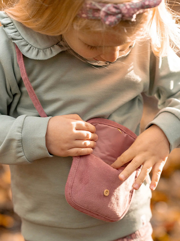 Child holding a pink bag with a blurred background